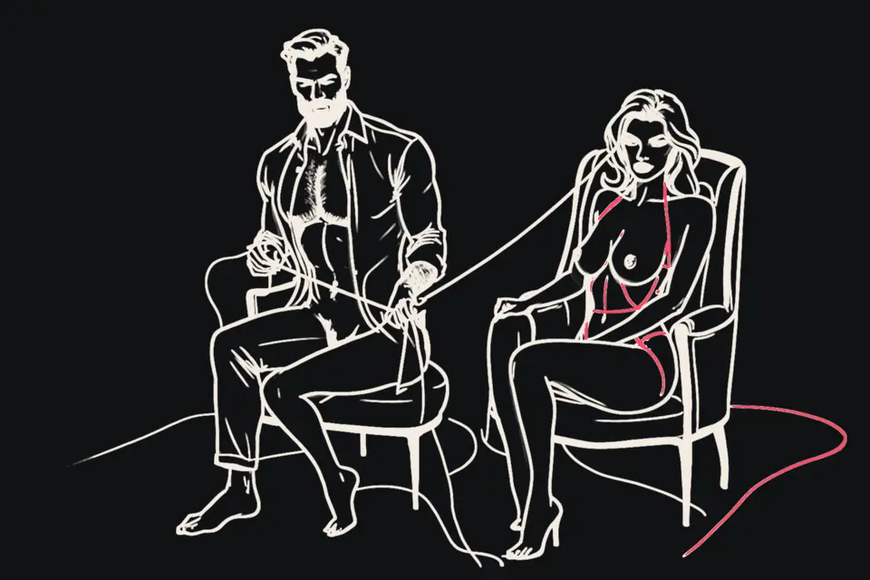A man in an armchair with a woman kneeling beside him