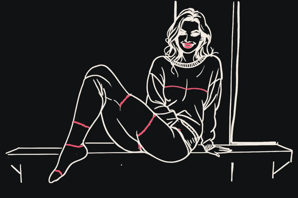 A woman in an oversized sweater sits on a windowsill