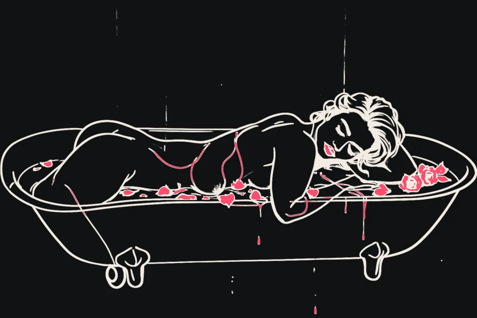 A woman relaxes in a bath with rose petals and a candle